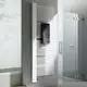 Vertikaler weißer Kermi-Heizkörper mit Längsrippen, montiert an einer hellen Wand. Ein Handtuch hängt dekorativ daran. Dusche im Hintergrund sichtbar.